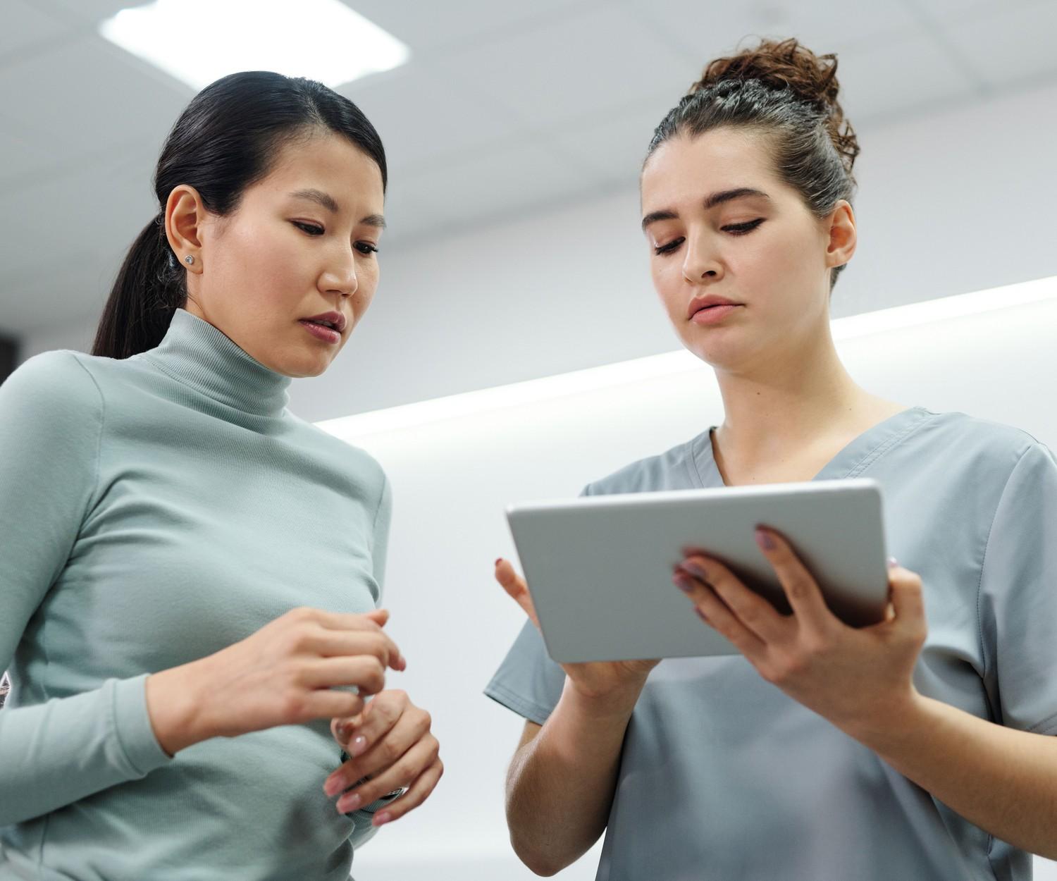A clinician and a patient reviewing information on a tablet together.